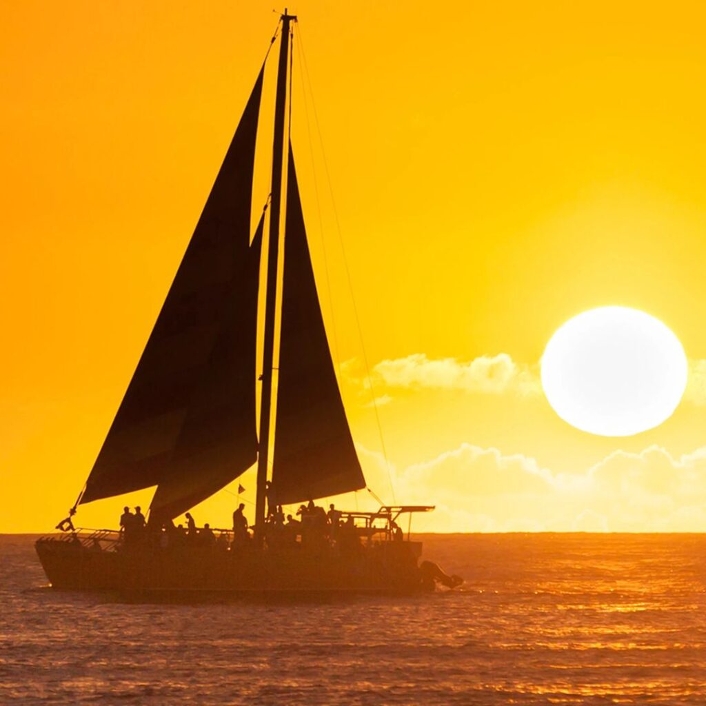 The 49 Best Things To Do In Kona Hawaii Calling a boat on the water with a sunset in the background