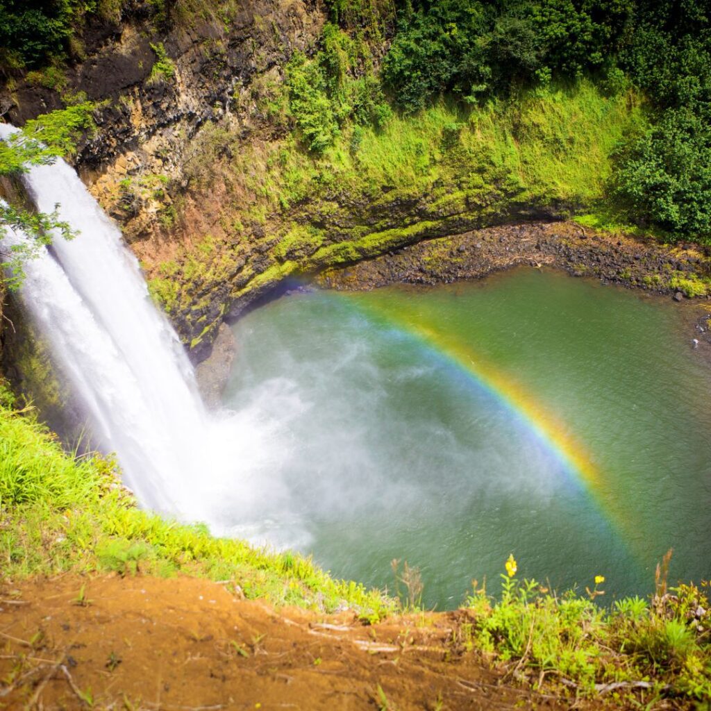 35 Best Things To Do On The Big Island Hawaii Calling a waterfall with a rainbow in the middle of a pool