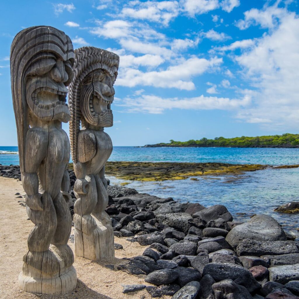 35 Best Things To Do On The Big Island Hawaii Calling a group of wooden statues on a beach