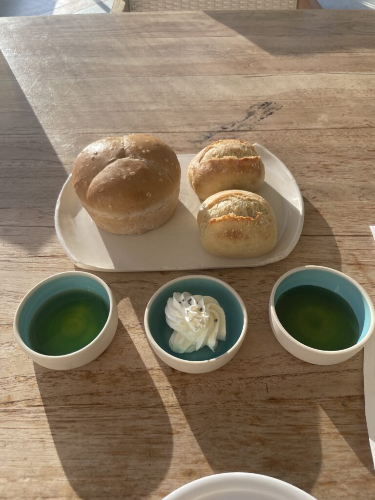 Review Montage Kapalua Bay | Maui Luxury Hawaii Calling a plate of bread and two small bowls of liquid on a table