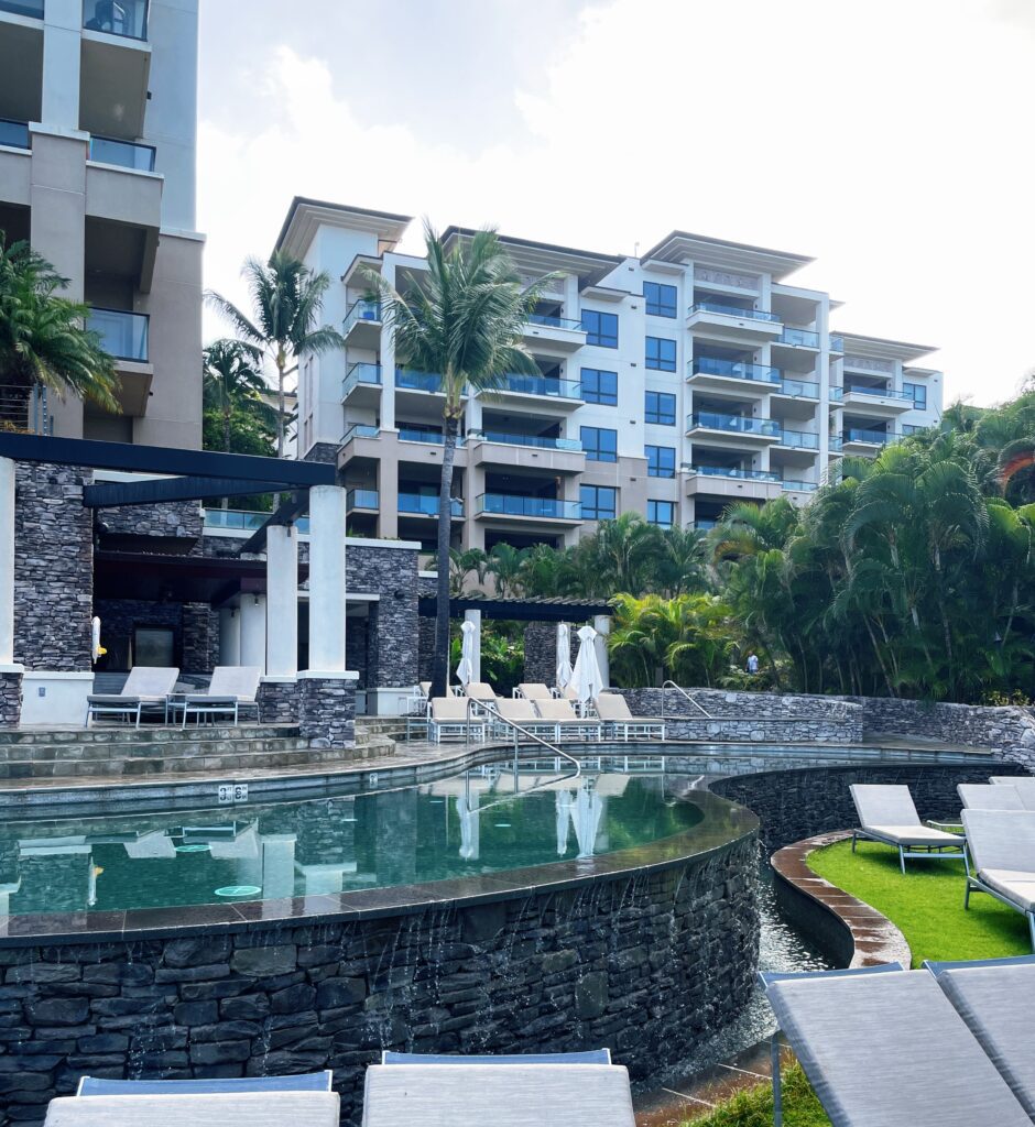Review Montage Kapalua Bay | Maui Luxury Hawaii Calling a pool with lounge chairs and a building in the background