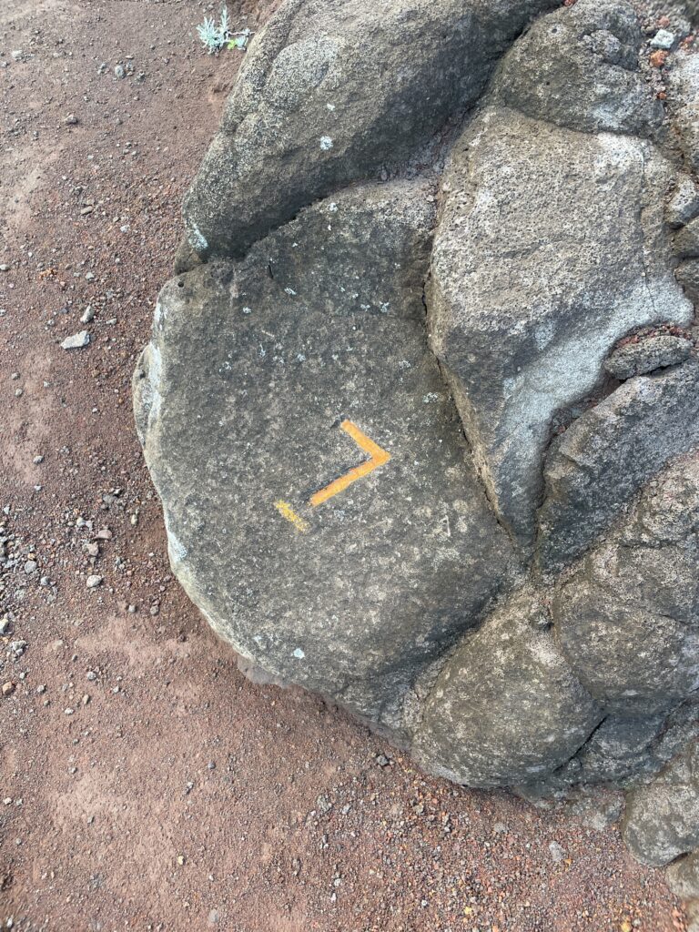 Kalalau Trail Adventure: My Unforgettable Hiking Experience on Kaua'i Hawaii Calling a rock with a yellow arrow on it