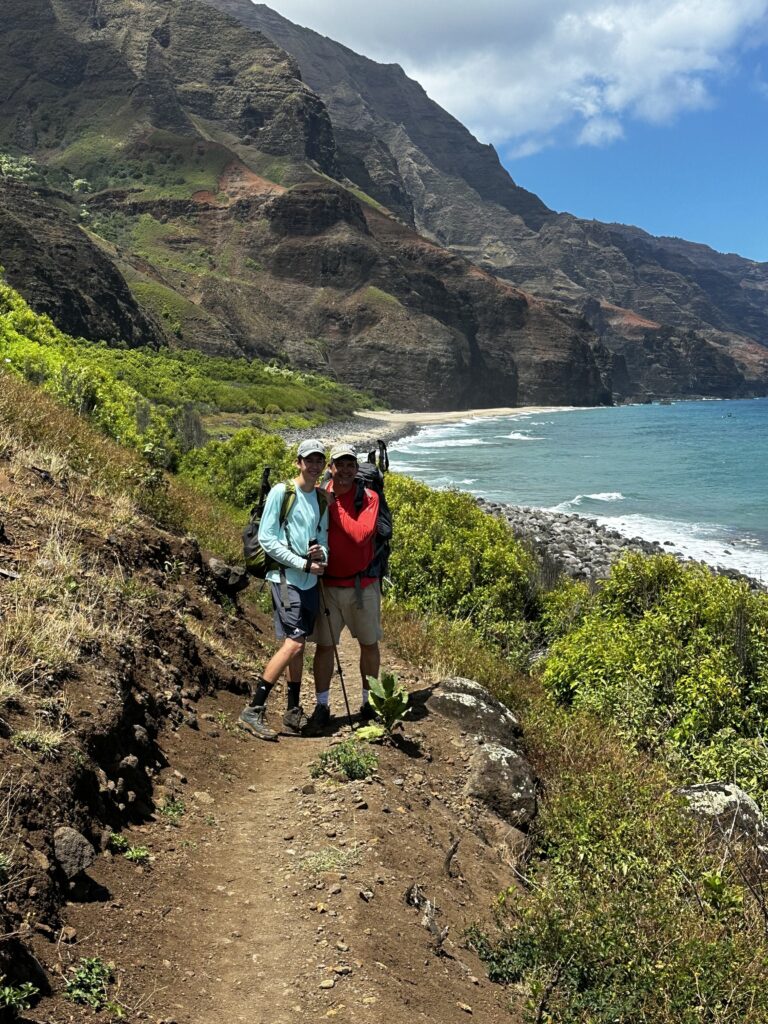 Kalalau Trail Adventure: My Unforgettable Hiking Experience on Kaua'i Hawaii Calling two people standing on a trail near a body of water
