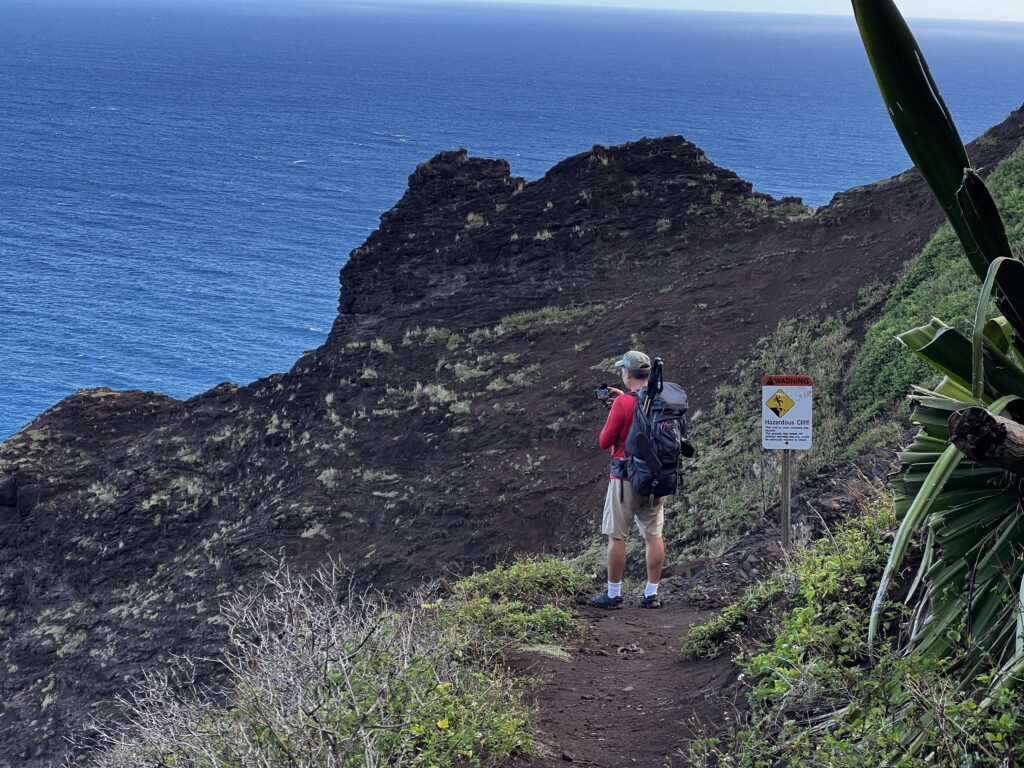 Kalalau Trail Adventure: My Unforgettable Hiking Experience on Kaua'i Hawaii Calling a man taking a picture of a cliff