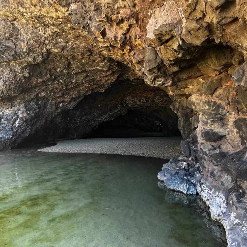 Kalalau Trail Adventure: My Unforgettable Hiking Experience on Kaua'i Hawaii Calling a cave with water in the background