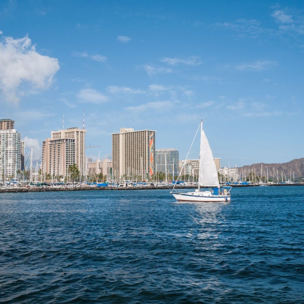 10 Breathtaking Honolulu Water Activities You Have To Experience (2025) Hawaii Calling a sailboat in the water with buildings in the background