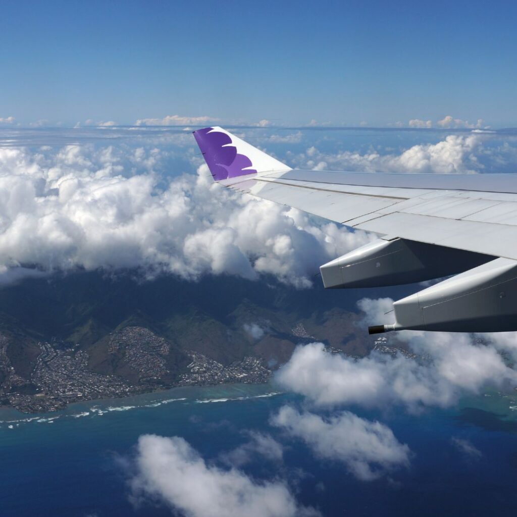 How Long Are Flights To Hawaii? A Look At The Timeline To Paradise Hawaii Calling an airplane wing above the clouds