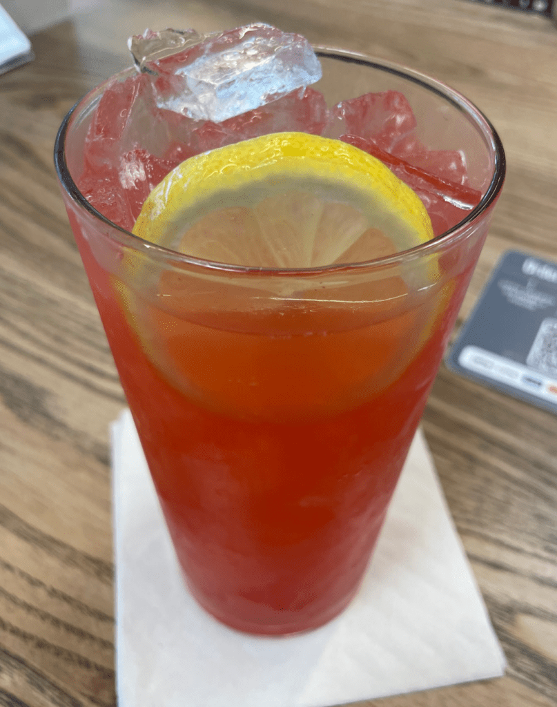 Mauka Market Restaurant Review | Excellent Food At Honolulu Airport Hawaii Calling a glass of red liquid with a lemon slice on top