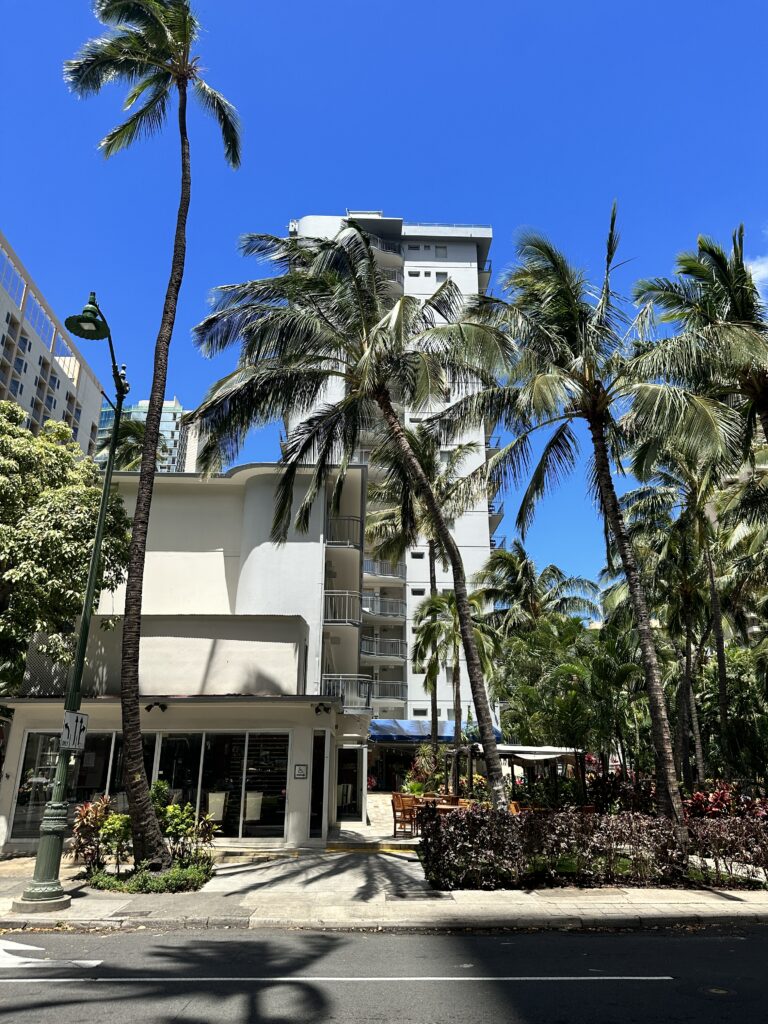 Courtyard by Marriott Waikiki Beach Review | Perfectly Positioned Hawaii Calling a building with palm trees and a street light