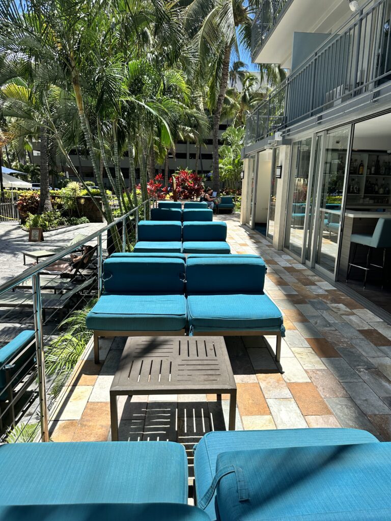 Courtyard by Marriott Waikiki Beach Review | Perfectly Positioned Hawaii Calling a patio with blue chairs and tables