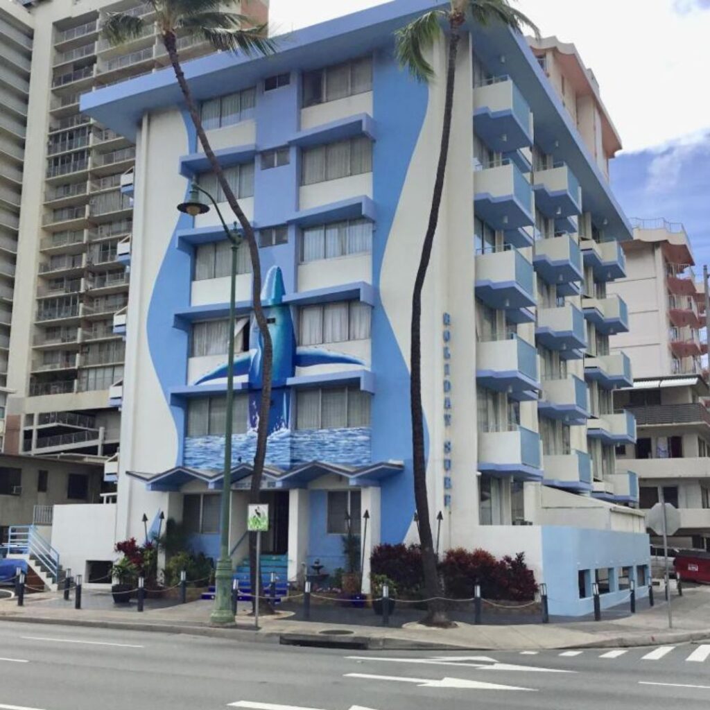 20 Best Budget Hotels On Oahu (2025) Comfort and Convenience for Every Wallet Hawaii Calling a building with palm trees and a street corner