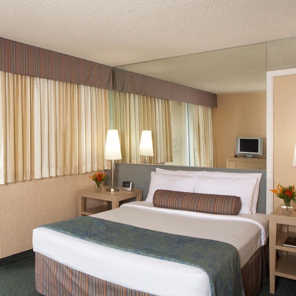 20 Best Budget Hotels On Oahu (2025) Comfort and Convenience for Every Wallet Hawaii Calling a hotel room with a bed and a mirror