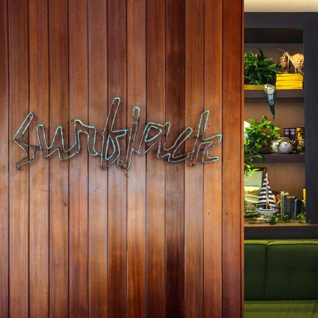 20 Best Budget Hotels On Oahu (2025) Comfort and Convenience for Every Wallet Hawaii Calling a wood wall with a sign and shelves