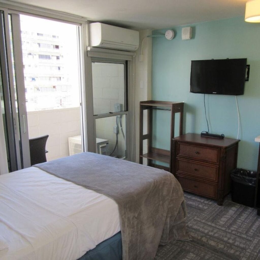 20 Best Budget Hotels On Oahu (2025) Comfort and Convenience for Every Wallet Hawaii Calling a bedroom with a bed and a television
