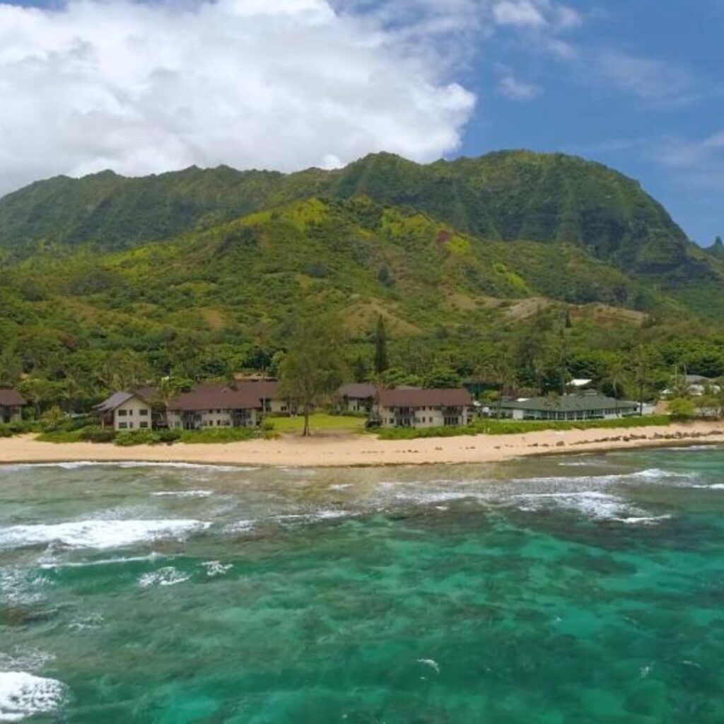15 Top-Rated Budget Hotels On Kaua'i: Affordable Luxury Hawaii Calling a beach with houses and a mountain in the background