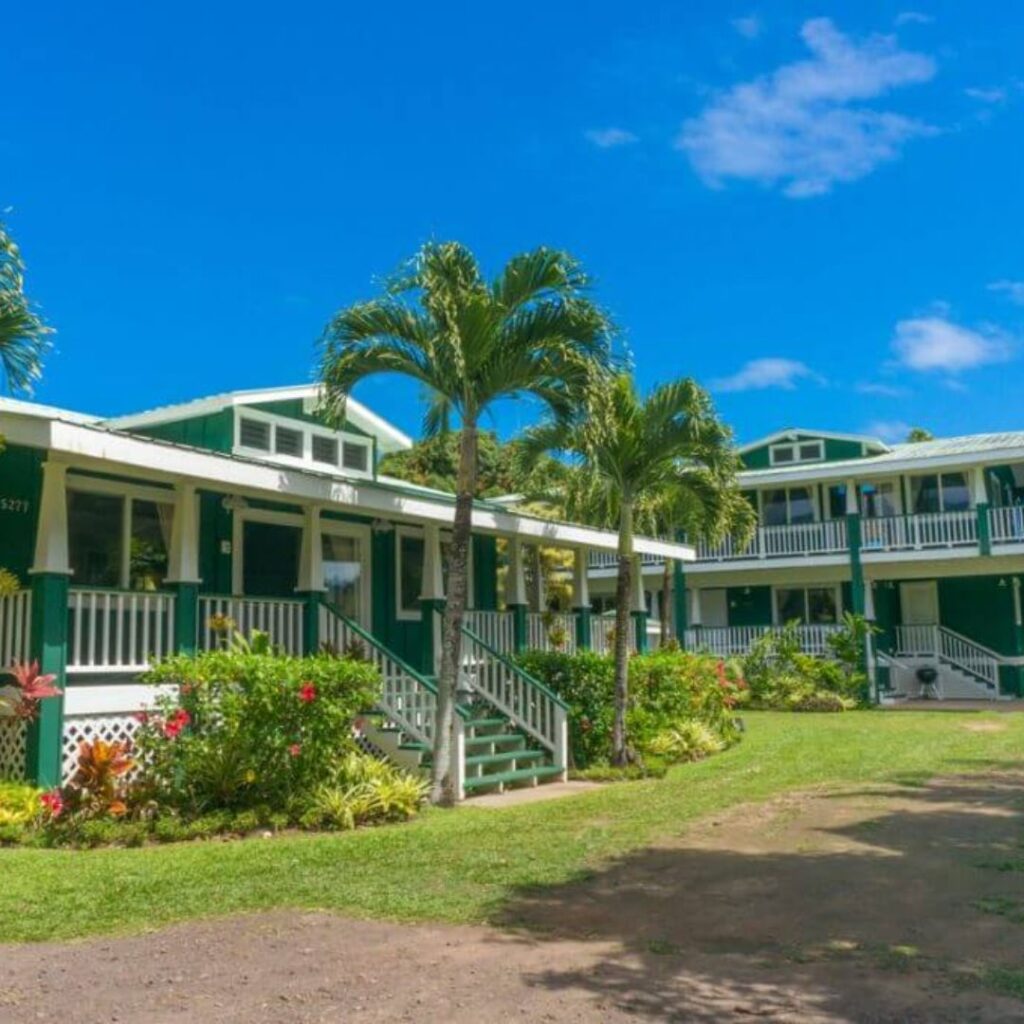 15 Top-Rated Budget Hotels On Kaua'i: Affordable Luxury Hawaii Calling a green building with palm trees and a path