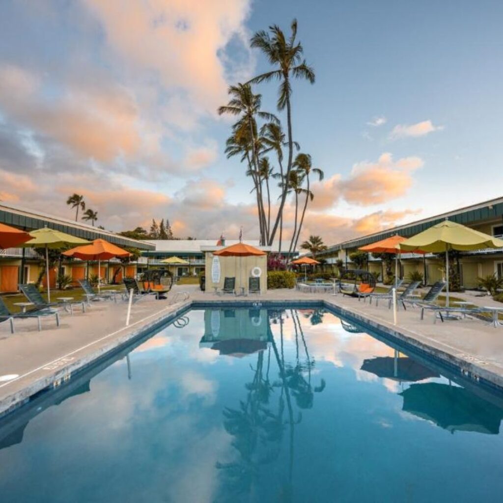 15 Top-Rated Budget Hotels On Kaua'i: Affordable Luxury Hawaii Calling a pool with umbrellas and palm trees