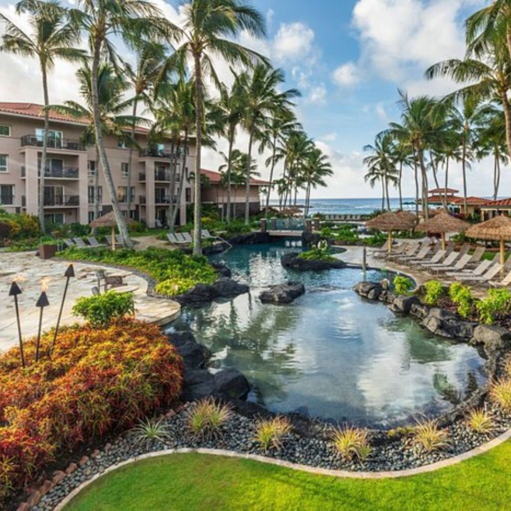 12 Best Family Hotels On Kaua'i for a Dream Hawaiian Vacation Hawaii Calling a pool with palm trees and a building