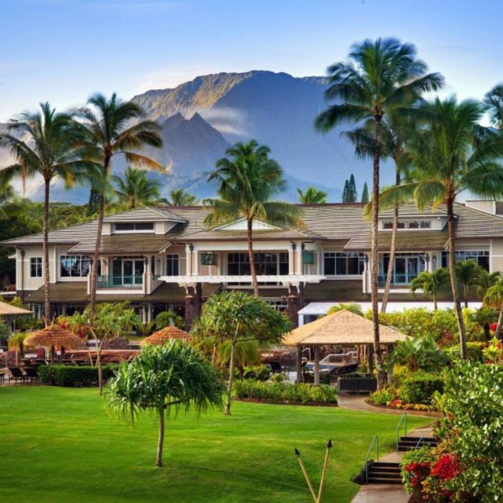 12 Best Family Hotels On Kaua'i for a Dream Hawaiian Vacation Hawaii Calling a large building with palm trees and a lawn