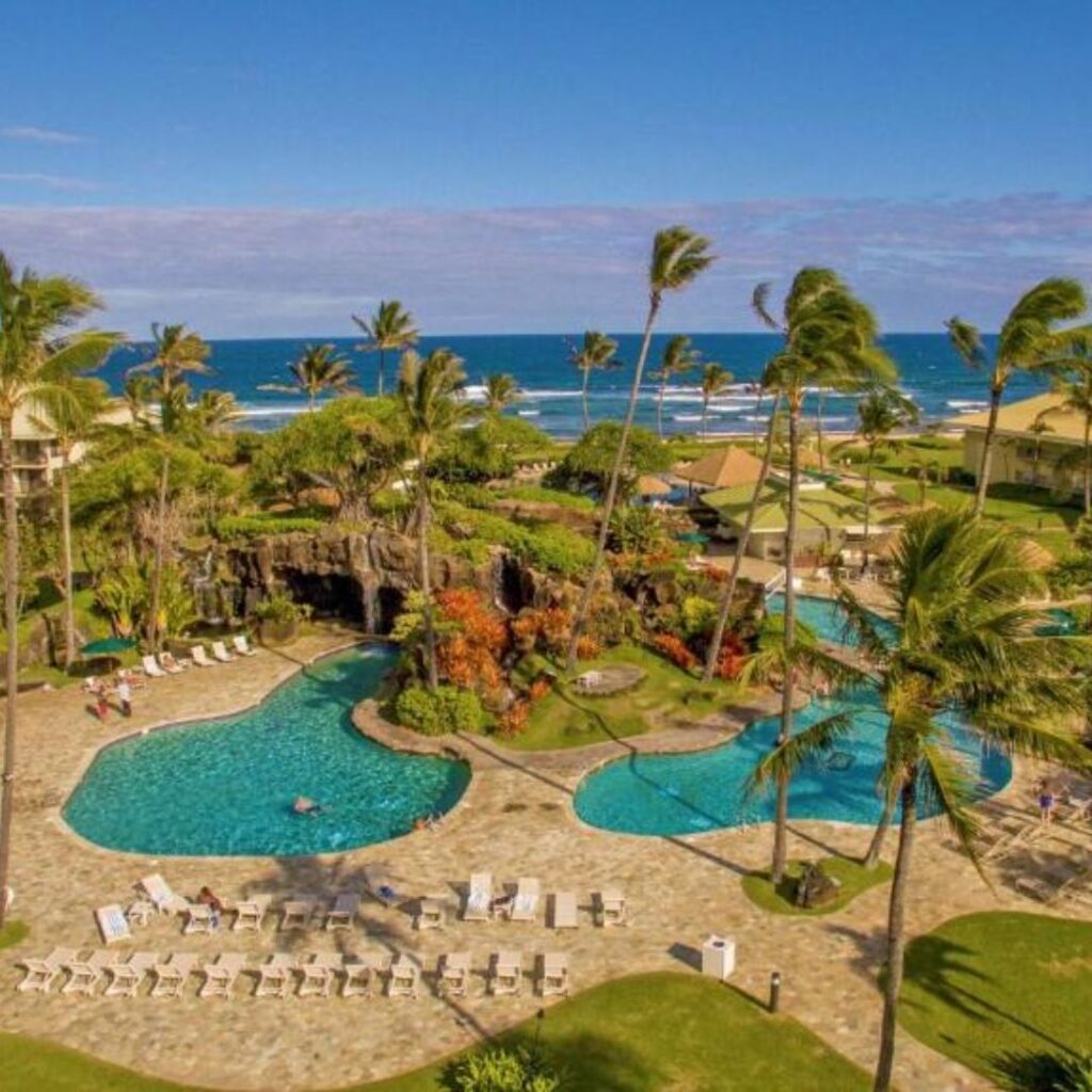 12 Best Family Hotels On Kaua'i for a Dream Hawaiian Vacation Hawaii Calling a swimming pool surrounded by palm trees and a beach