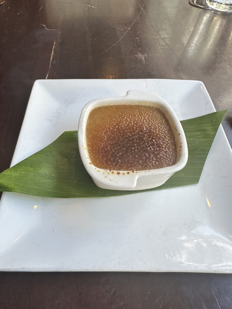 Kalo Hawaiian Food by Chai's | Unique Flavors In Waikiki Hawaii Calling a bowl of brown liquid on a leaf on a white plate
