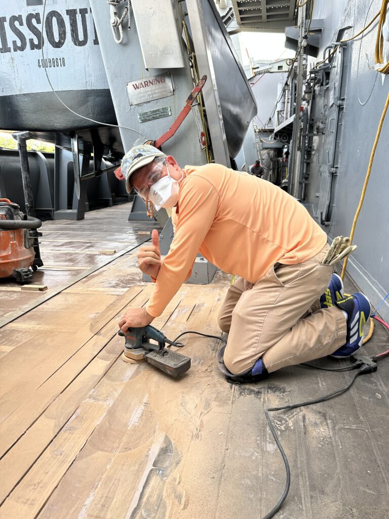 Volunteering At The Battleship Missouri Memorial | Amazing History Behind The Scenes Hawaii Calling a man wearing a mask and gloves while using a sanding machine