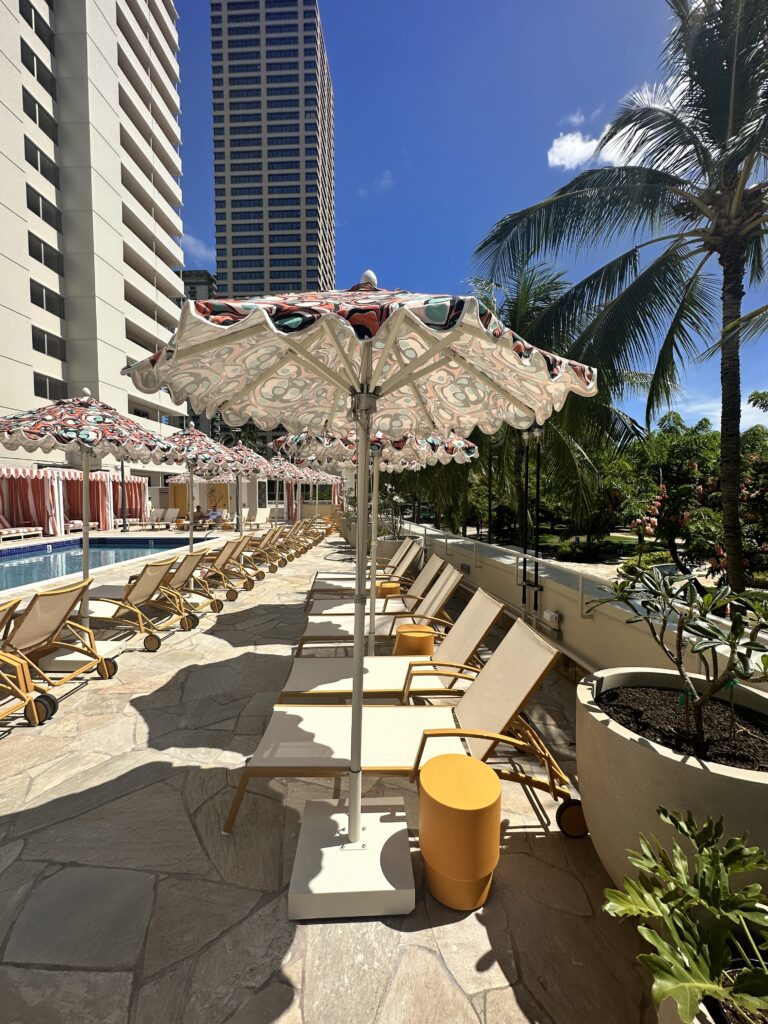 Romer Waikiki Sneak Peek | Renovations Complete Hawaii Calling a pool with umbrellas and lounge chairs