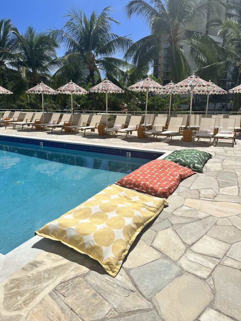 Romer Waikiki Sneak Peek | Renovations Complete Hawaii Calling a pool with pillows and umbrellas