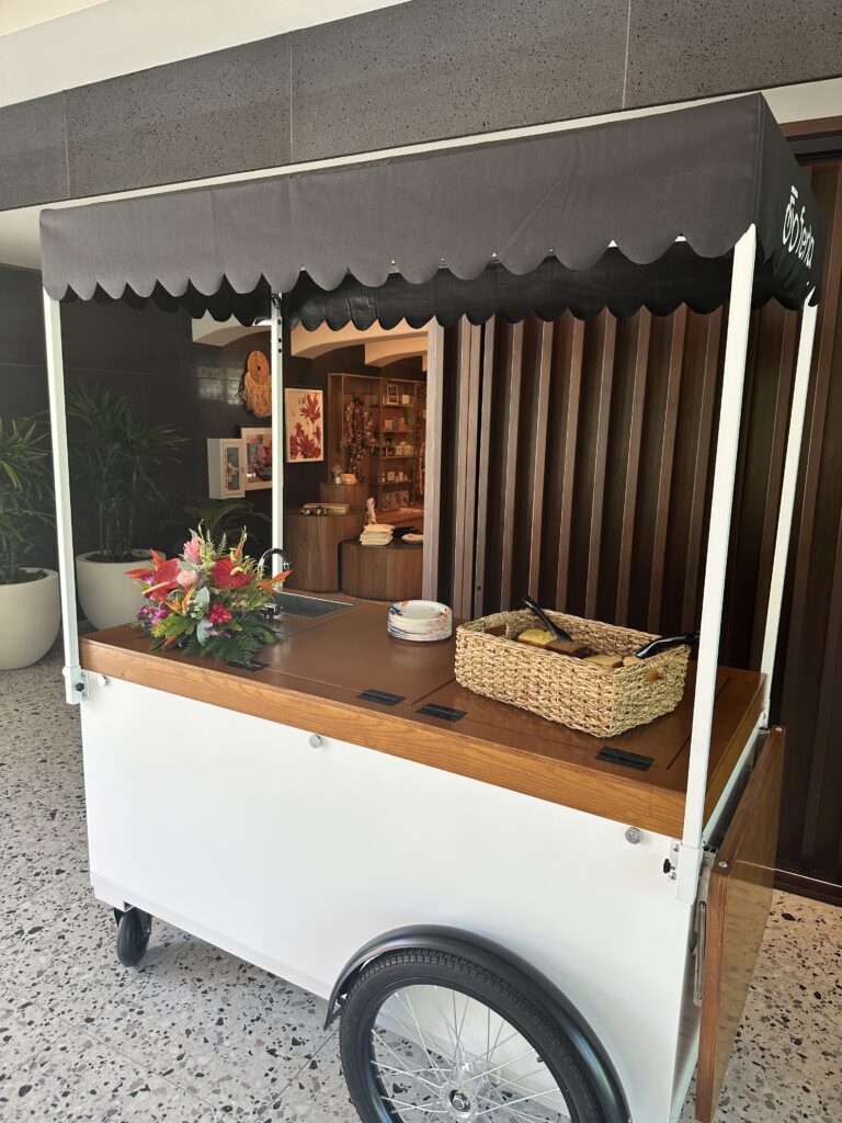 Romer Waikiki Sneak Peek | Renovations Complete Hawaii Calling a cart with a basket of food on it