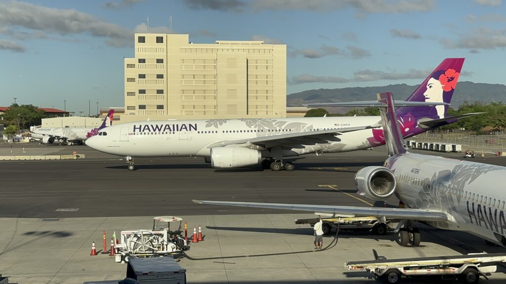 Review: Hawaiian Airlines Boeing 717 Economy HNL-KOA Hawaii Calling a large white airplane on a runway