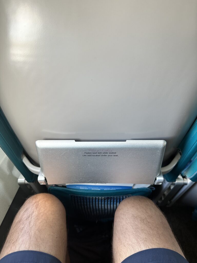 Review: Hawaiian Airlines Boeing 717 Economy HNL-KOA Hawaii Calling a person's legs and a tablet on a seat