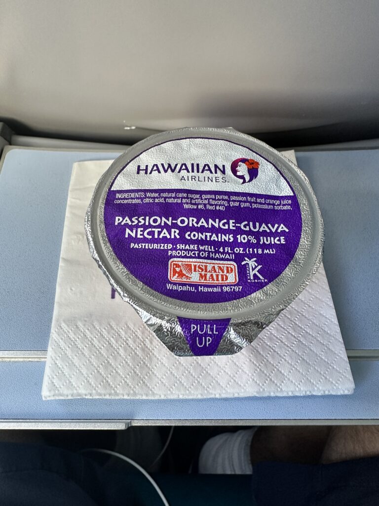 Review: Hawaiian Airlines Boeing 717 Economy HNL-KOA Hawaii Calling a round container of food on a napkin