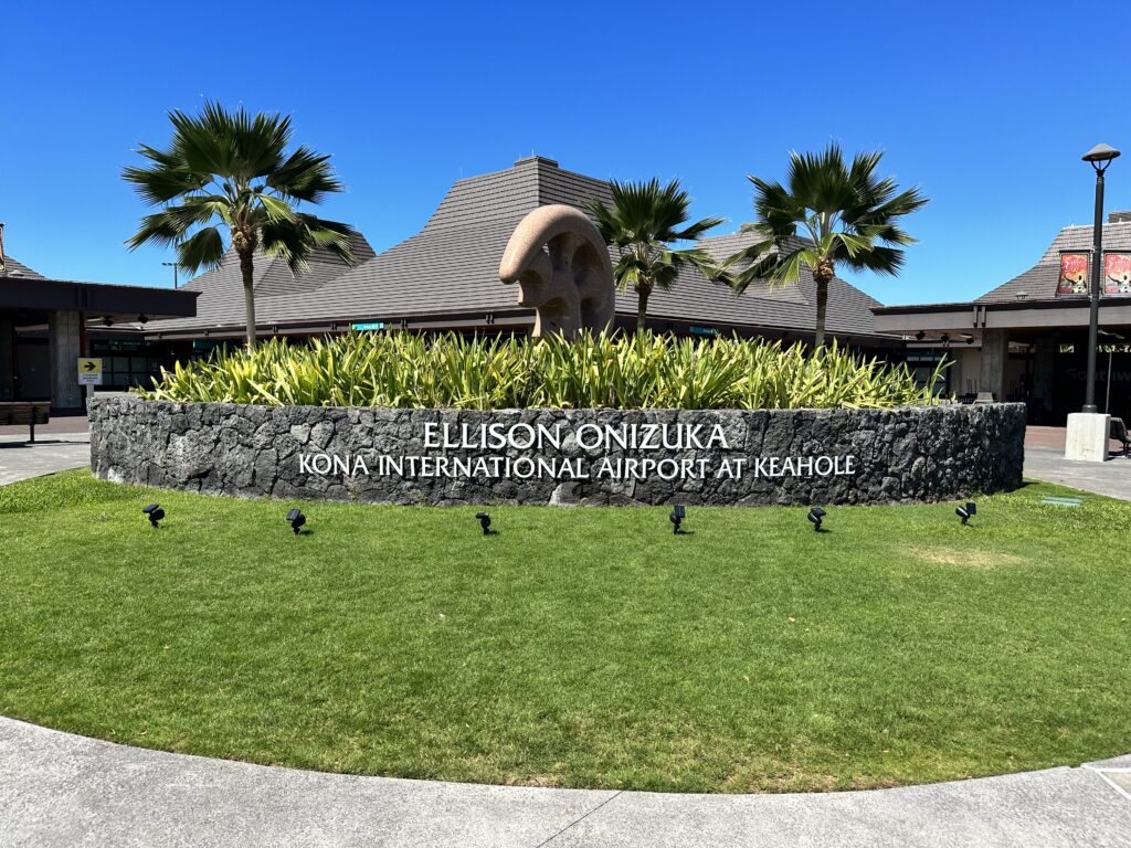 Review: Hawaiian Airlines Boeing 717 Economy HNL-KOA Hawaii Calling a building with palm trees and a stone wall
