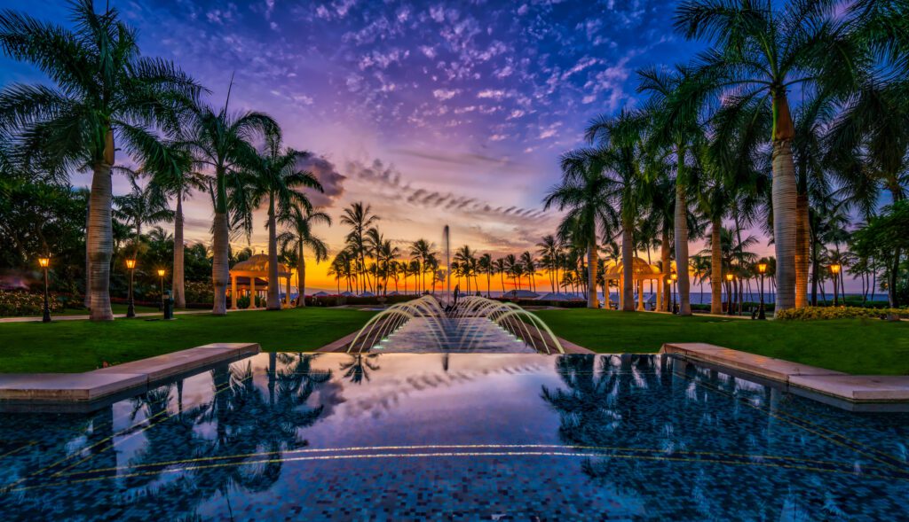 13 Best Luxury Hotels in Hawaii (2025) Hawaii Calling a pool with water and palm trees in the background