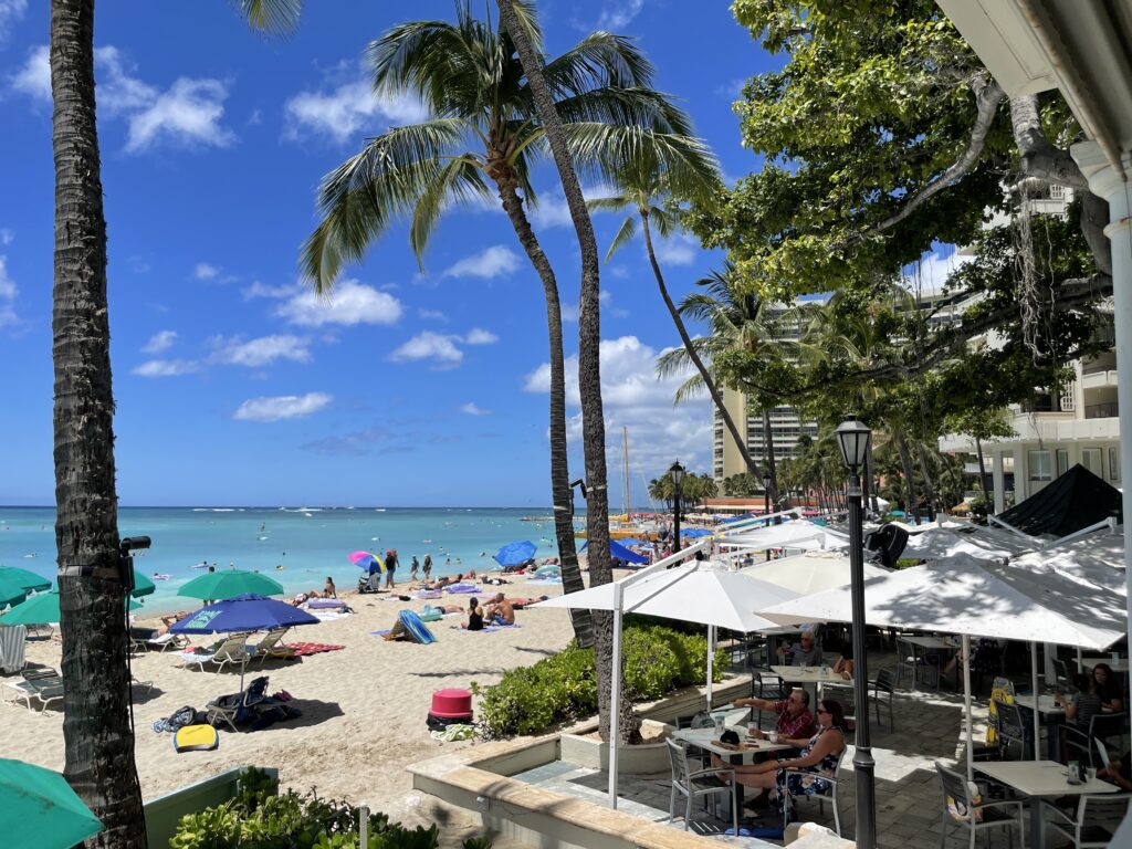 15 Best Beachfront Hotels On Oahu (2025) | Waterfront Bliss Hawaii Calling a beach with umbrellas and people on it