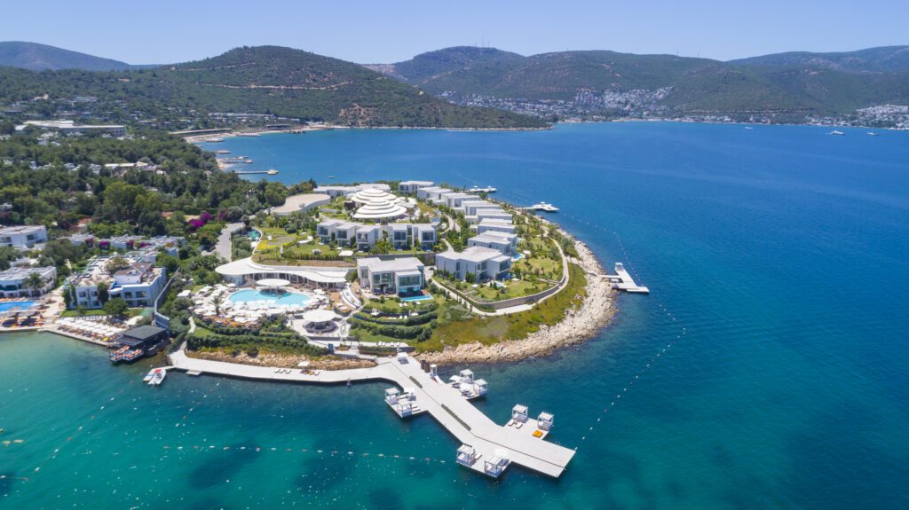 Guide to Hilton Impresario: Exclusive Perks For Luxury Stays Hawaii Calling a large island with a pool and a building on it