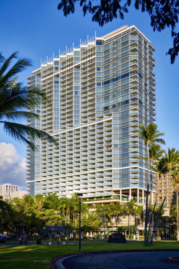 Rebranding Elegance: Unveiling Wākea Waikiki Beach, the Ex-Trump Waikiki Hotel's New Chapter with Hilton LXR Hawaii Calling a tall building with many windows