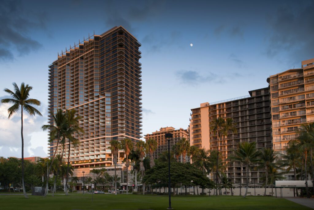 Rebranding Elegance: Unveiling Wākea Waikiki Beach, the Ex-Trump Waikiki Hotel's New Chapter with Hilton LXR Hawaii Calling a tall buildings with palm trees