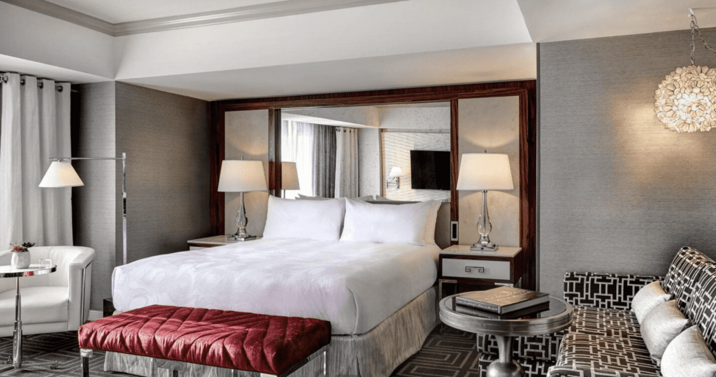 The 7 Best Marriott Hotels in San Francisco Hawaii Calling a bed with a red bench and lamps in a hotel room