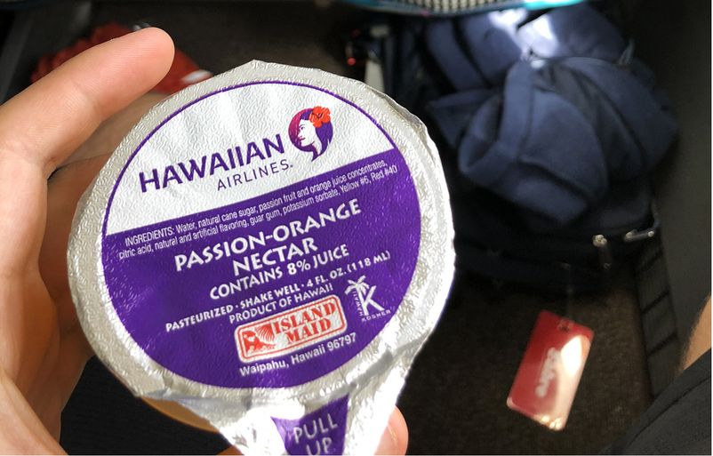 Hawai'i Travel Updates for December 2023 Hawaii Calling a hand holding a purple and white package