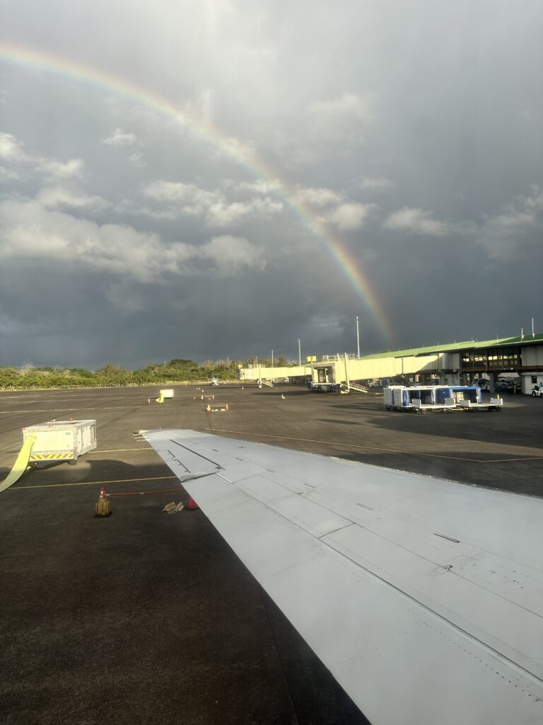 Review: Hawaiian Airlines Hilo To Honolulu | Boeing 717 | ITO-HNL Hawaii Calling a rainbow over a building and a plane wing