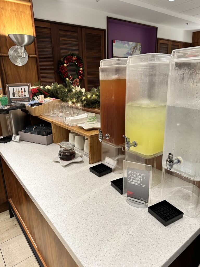 Delta Sky Club Honolulu | Guide & Review (2025) Hawaii Calling a row of drinks dispensers on a counter