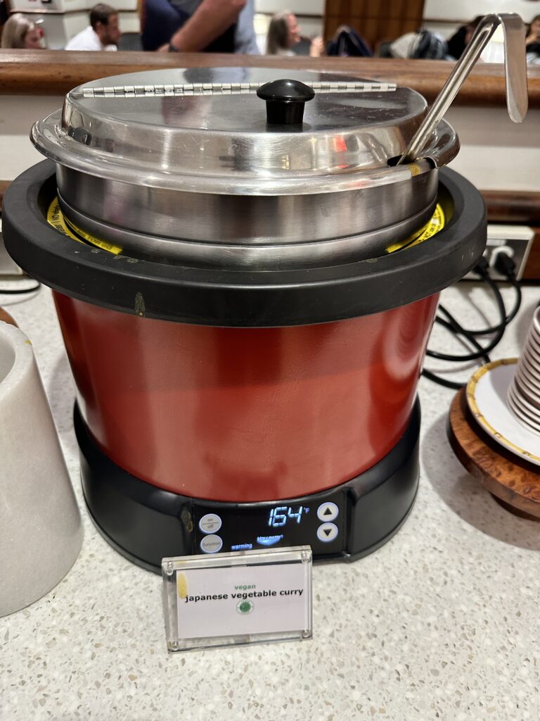 Delta Sky Club Honolulu | Guide & Review (2025) Hawaii Calling a red and black pot with a lid and spoons