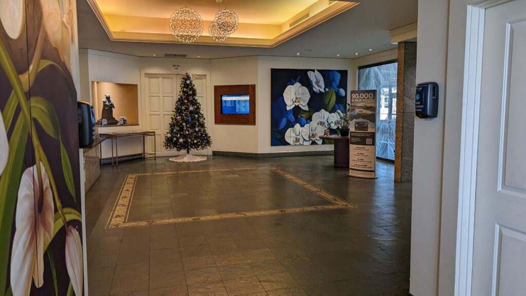 United Airlines Club Honolulu | Unique & Spacious Hawaii Calling a room with a christmas tree and a painting on the wall