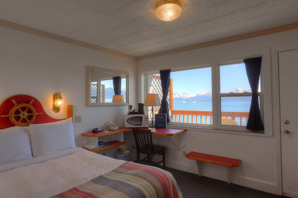 The 5 Best Budget Hotels in Alaska (2024) Hawaii Calling a room with a bed and a desk and a window with a view of the ocean