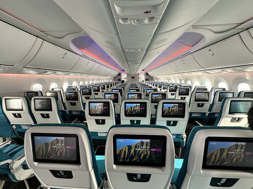 Hawaiian Airlines Boeing 787 Dreamliner Walk Through Hawaii Calling an airplane with rows of seats and monitors