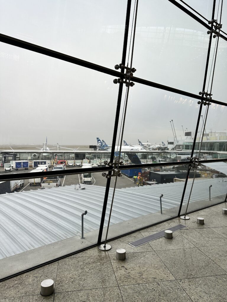 Review: Alaska Airlines Boeing 737 Max 9 First Class SEA-HNL Hawaii Calling a view of a large glass window at an airport