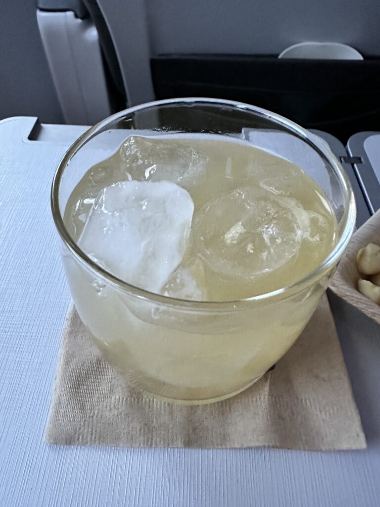 Review: Alaska Airlines Boeing 737 Max 9 First Class SEA-HNL Hawaii Calling a glass of liquid with ice and a spoon of nuts