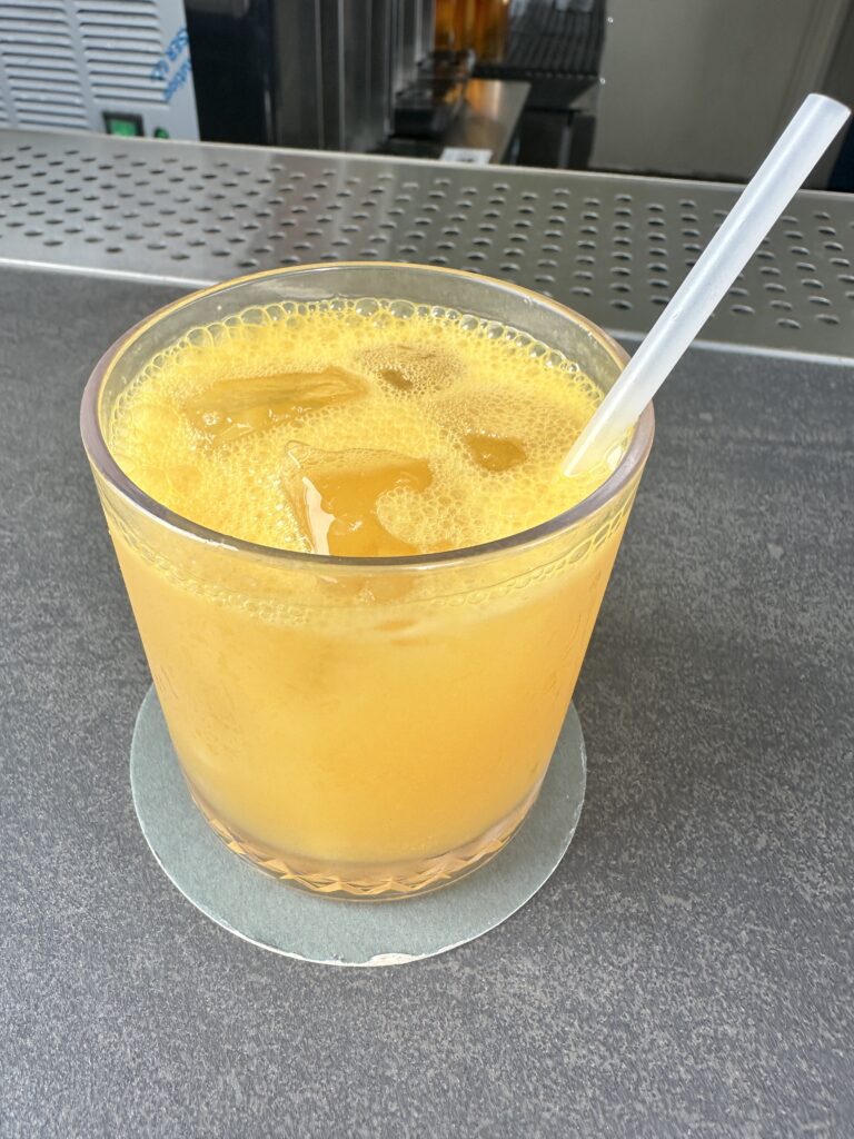 Review: Renaissance Honolulu Hotel & Spa | Oahu's Newest Hotel Hawaii Calling a glass of orange liquid with a straw