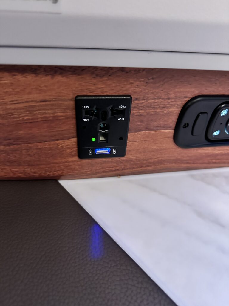 A First Class Experience on Hawaiian Airlines Boeing 787 Dreamliner | Leihōkū Suites | HNL-SFO Hawaii Calling a close up of a power outlet